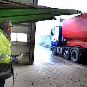 Chauffeur Nico Bijland bestuurt via een afstand bediening de boxenvuller, zodat hij de vrachtwagen op de juiste manier vol laadt.