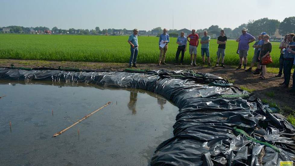 Het is belangrijk dat de grond continu onder water staat, zegt Egbert Schepel van het HLB (links) tegen de bezoekers van de Aardappeldag. 'Anders is het effect weg.' Waarschijnlijk blijft het zo liggen tot oktober, november. Als de grond na deze proef vri