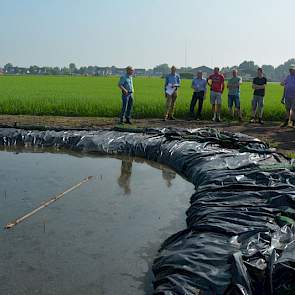 Het is belangrijk dat de grond continu onder water staat, zegt Egbert Schepel van het HLB (links) tegen de bezoekers van de Aardappeldag. 'Anders is het effect weg.' Waarschijnlijk blijft het zo liggen tot oktober, november. Als de grond na deze proef vri