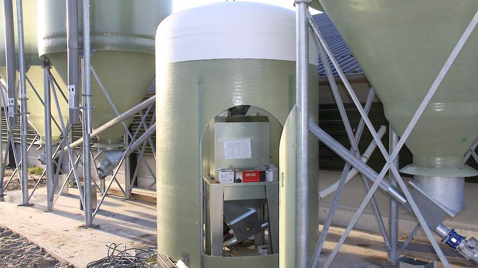 Bij de nieuwe stal staan net zoals de andere stallen drie silo’s. Eén voor tarwe en twee voor het kernvoer waarvan één voor het eindvoer. De weger staat in een silohut. Alle silo’s op zijn bedrijf beschikken over een aftappunt. „In de tarwe zit vaak veel