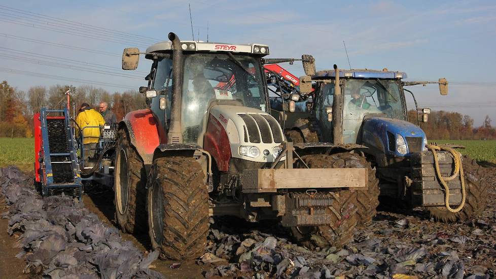 Zoon Maurijn rijdt op de trekker voor de kooloogstmachine.