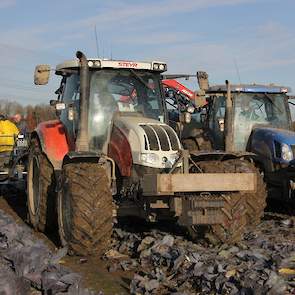 Zoon Maurijn rijdt op de trekker voor de kooloogstmachine.