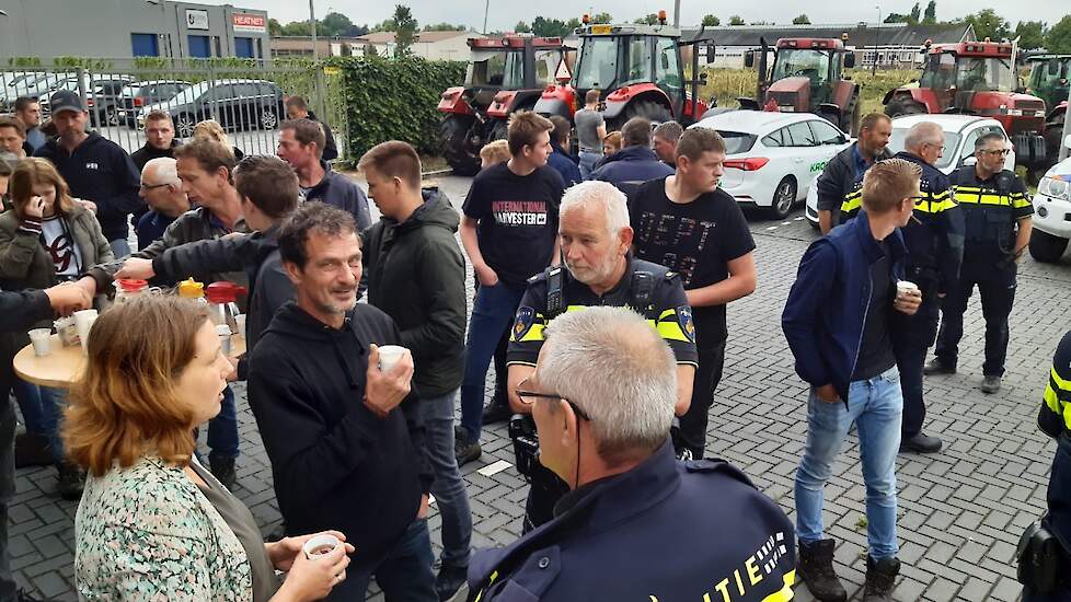 De sfeer voor het politiebureau is goed. Boeren en agenten drinken samen koffie.