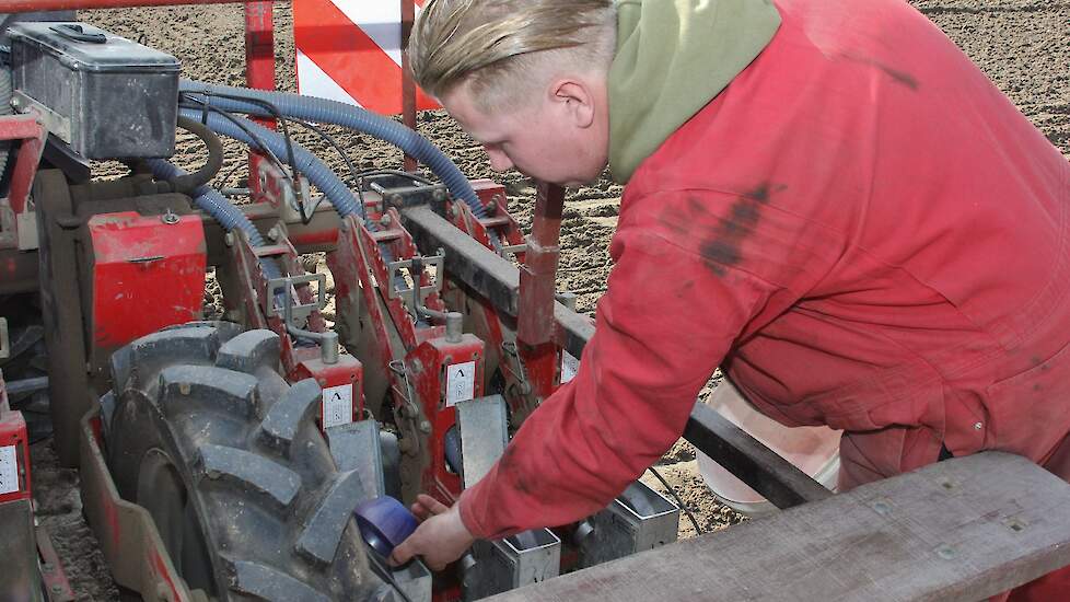 Het opgezogen zaad wordt opgevangen in een klein buffervat op de 12-rijige machine. Van daaruit wordt het uiteindelijk overgegoten in een opslagzak.