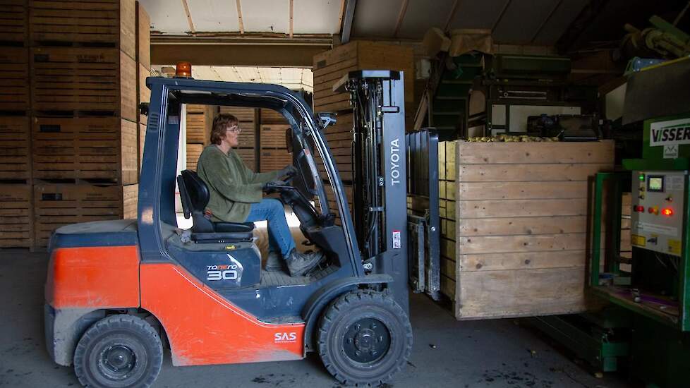 Moeder Silvia is ook volop actief bij het inschuren. Vader Hans is de laatste late tafelaardappels nog aan het spuiten.